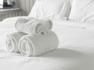 respite-care Folded towels on bed at Villa de San Antonio Senior Living